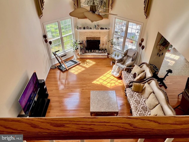 4718 Village Dr, Fairfax, VA 22030 - living area with a towering ceiling, wood finished floors, a high end fireplace, and a ceiling fan