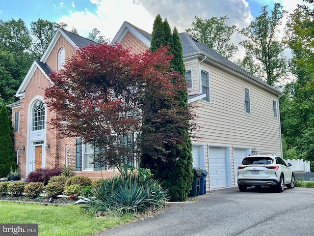 4718 Village Dr, Fairfax, VA 22030 - view of front of home featuring a garage, asphalt driveway, and brick siding