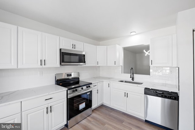 1065 Old Forge Rd, New Castle, DE 19720 - kitchen with stainless steel appliances, a sink, white cabinets, and light stone counters