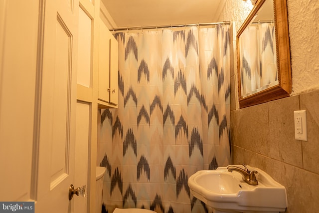89 Main St N, Kilmarnock, VA 22482 - full bath with tile walls, toilet, a shower with shower curtain, and a sink