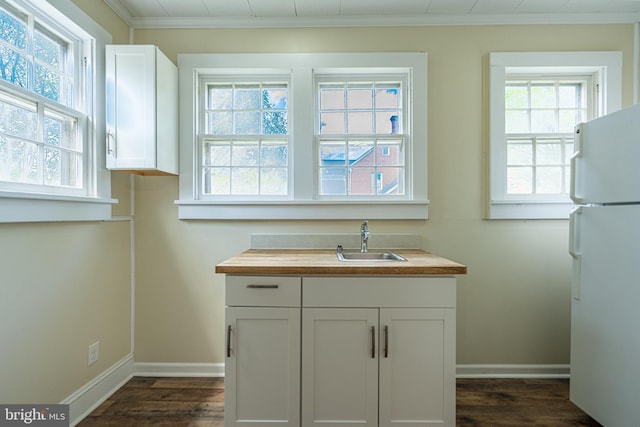 89 Main St N, Kilmarnock, VA 22482 - kitchen featuring freestanding refrigerator, butcher block counters, a sink, dark wood-type flooring, and baseboards