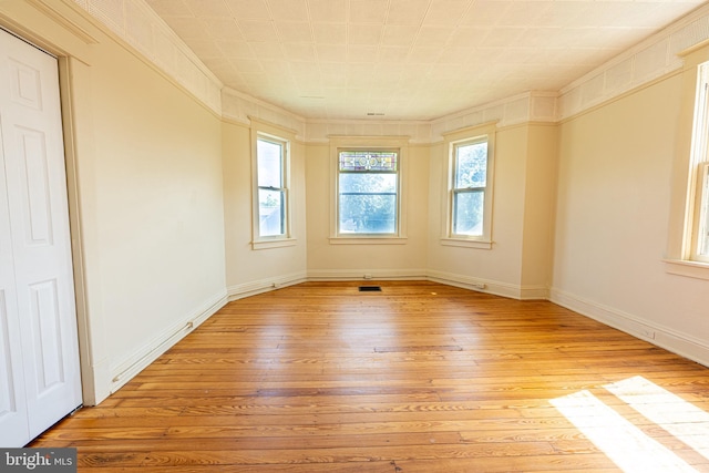 89 Main St N, Kilmarnock, VA 22482 - unfurnished room with light wood-style flooring, baseboards, and crown molding