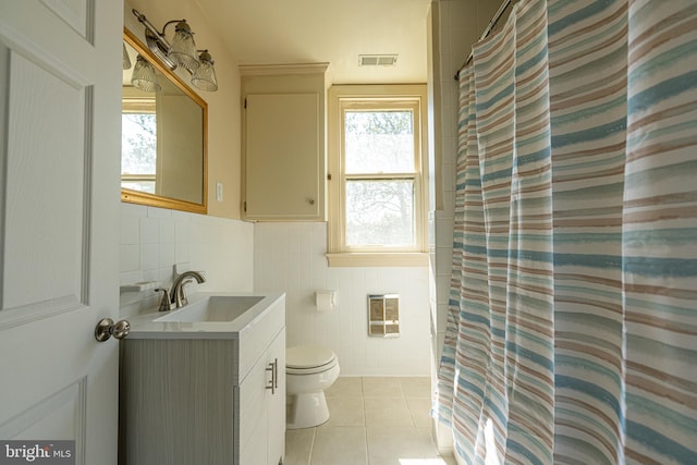 89 Main St N, Kilmarnock, VA 22482 - bathroom with tile walls, tile patterned floors, toilet, healthy amount of natural light, and vanity