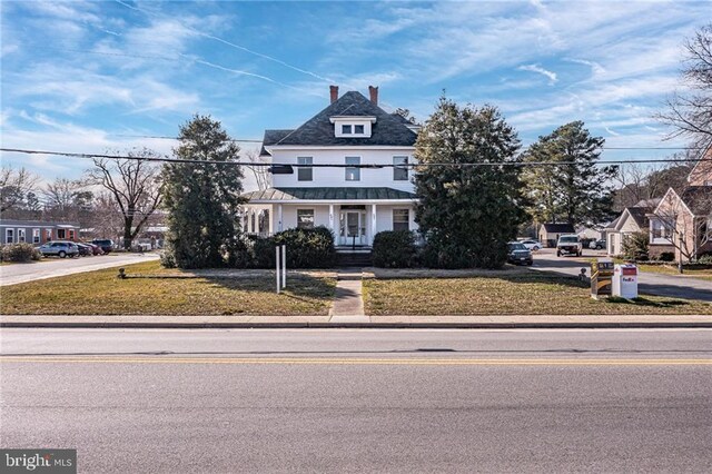 89 Main St N, Kilmarnock, VA 22482 - view of front of home with a front yard, a standing seam roof, metal roof, and a chimney