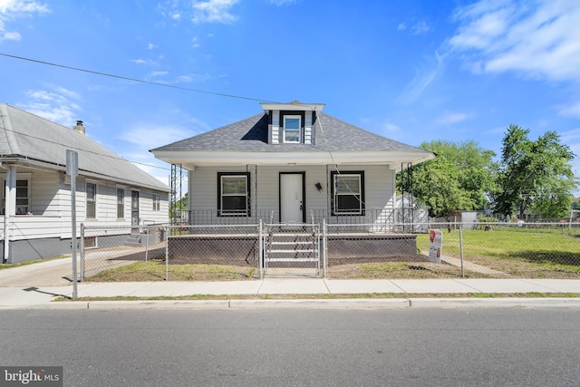 311 W Washington St, Paulsboro, NJ 08066 - view of front of property with covered porch, a gate, a shingled roof, and a fenced front yard
