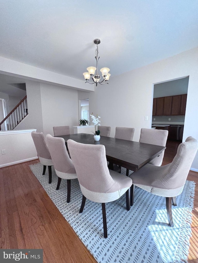 43103 Lake Ridge Pl, Leesburg, VA 20176 - dining room with a chandelier, wood finished floors, stairs, and baseboards