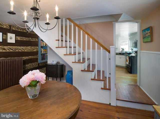 1180 Radnor Hill Rd, Wayne, PA 19087 - stairs featuring radiator, hardwood / wood-style floors, and a chandelier