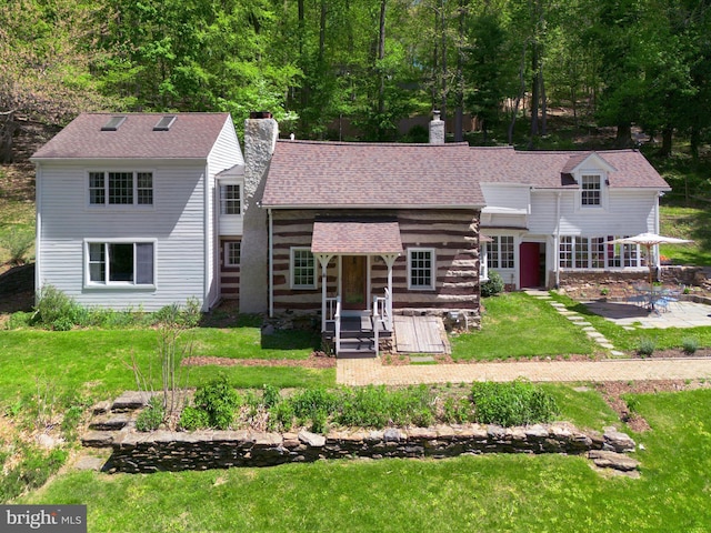 1180 Radnor Hill Rd, Wayne, PA 19087 - view of front facade with a chimney, a patio area, a front lawn, and roof with shingles