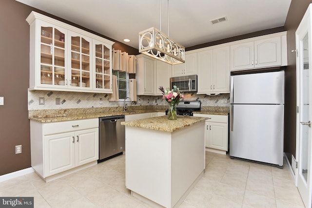 14 Coolidge Way, Princeton, NJ 08540 - kitchen featuring appliances with stainless steel finishes, decorative backsplash, glass insert cabinets, pendant lighting, and light stone counters