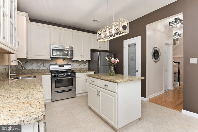 14 Coolidge Way, Princeton, NJ 08540 - kitchen with stainless steel appliances, a sink, light tile patterned flooring, backsplash, and white cabinetry