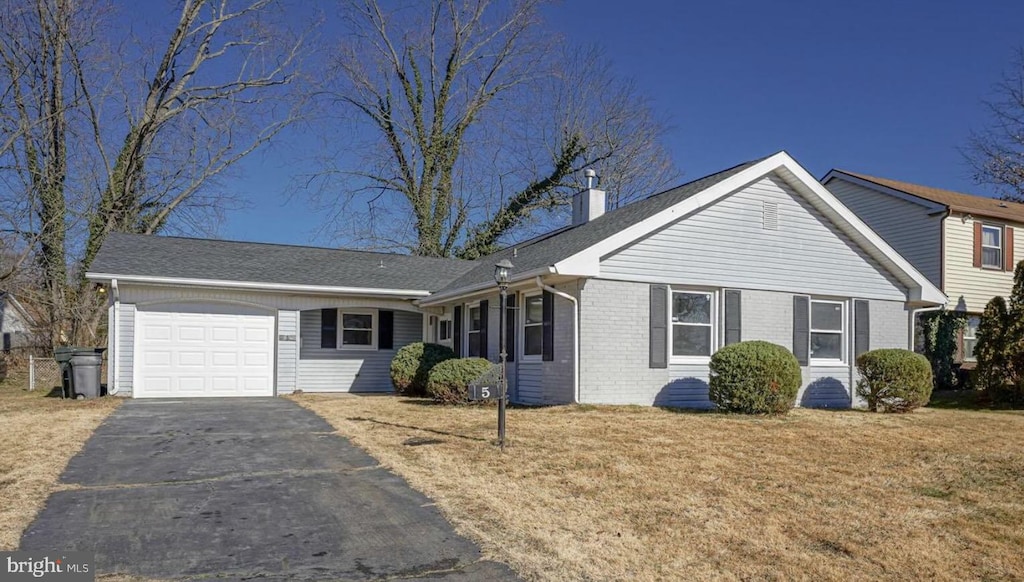5 Parish Ln, Willingboro, NJ 08046 - view of front of house with a garage, driveway, a chimney, brick siding, and a front yard