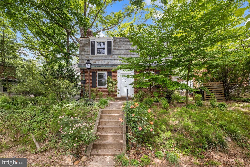 7306 Wildwood Dr, Takoma Park, MD 20912 - view of front of house with brick siding, a chimney, and mansard roof