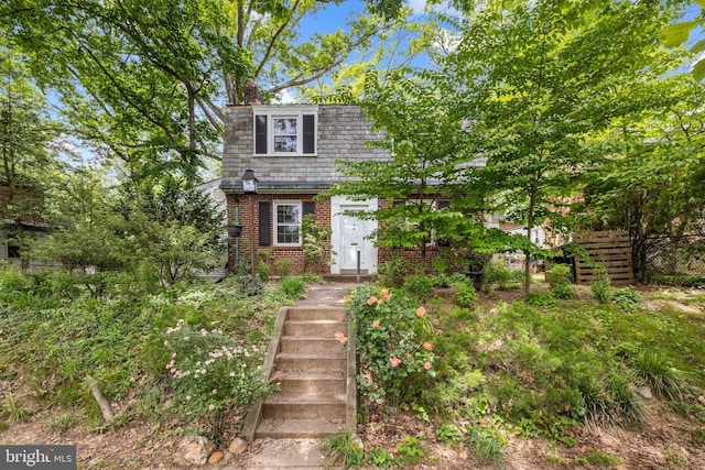7306 Wildwood Dr, Takoma Park, MD 20912 - view of front of house with brick siding, a chimney, and mansard roof