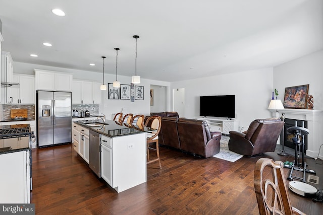 1606 Trotter St, Frederick, MD 21702 - kitchen featuring appliances with stainless steel finishes, dark countertops, a kitchen bar, dark wood-type flooring, and recessed lighting