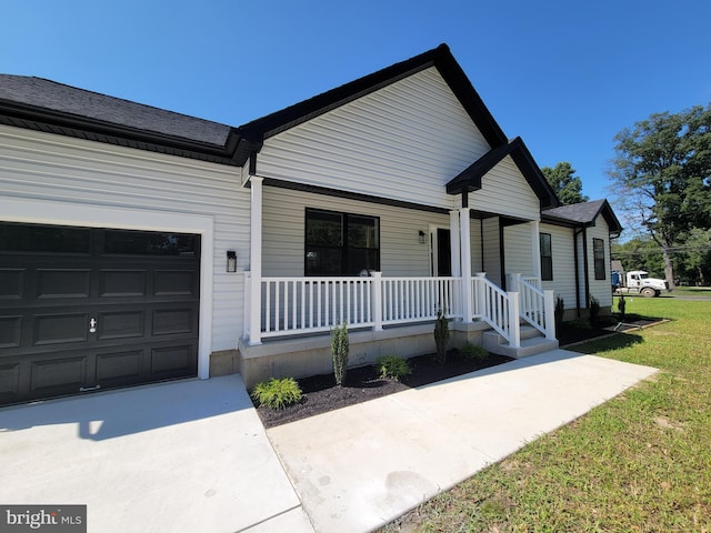view of front of property with a porch, a garage, and roof with shingles