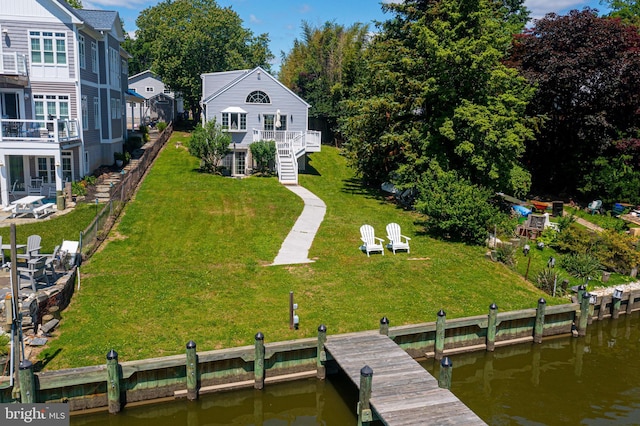 rear view of house with a deck with water view and stairs
