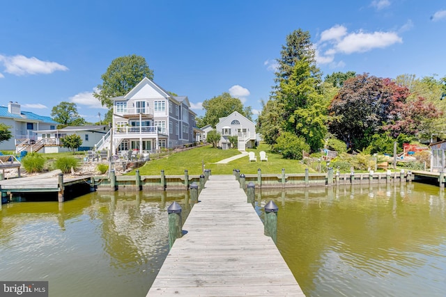 dock featuring a water view, stairs, and a yard