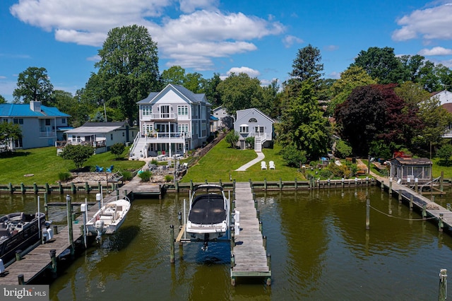 dock area featuring boat lift, stairway, a yard, a deck with water view, and view of wooded area