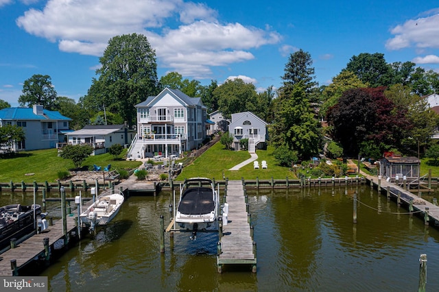 dock area with boat lift, a water view, and a lawn