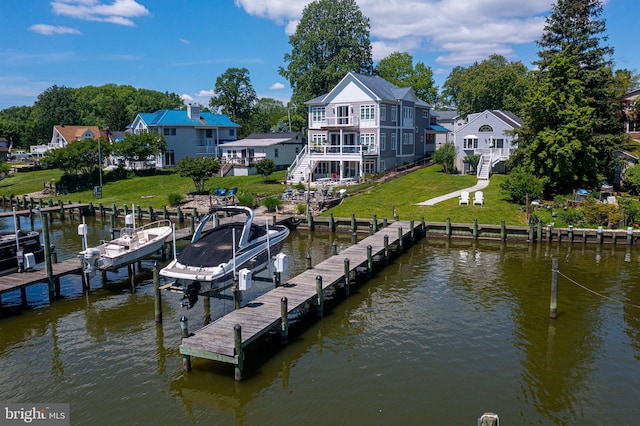 dock with stairs, boat lift, a yard, a balcony, and a deck with water view