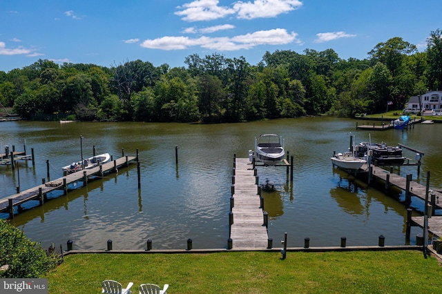 dock featuring boat lift, a water view, and a lawn
