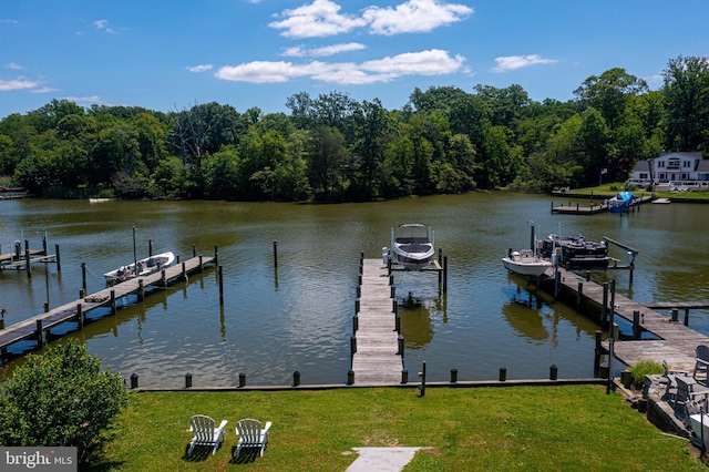 dock with boat lift, a water view, and a lawn