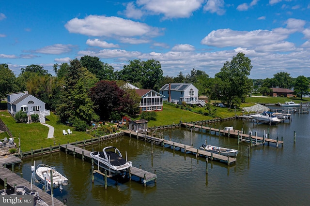 dock area with boat lift, a water view, and a lawn