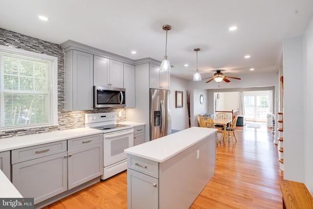 kitchen featuring appliances with stainless steel finishes, gray cabinetry, backsplash, recessed lighting, and light wood-type flooring