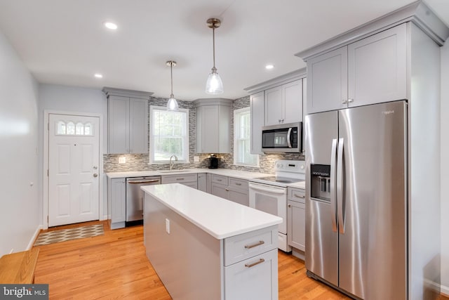 kitchen featuring appliances with stainless steel finishes, a sink, gray cabinets, tasteful backsplash, and recessed lighting