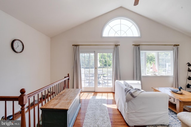 living area featuring plenty of natural light, vaulted ceiling, wood finished floors, and a ceiling fan