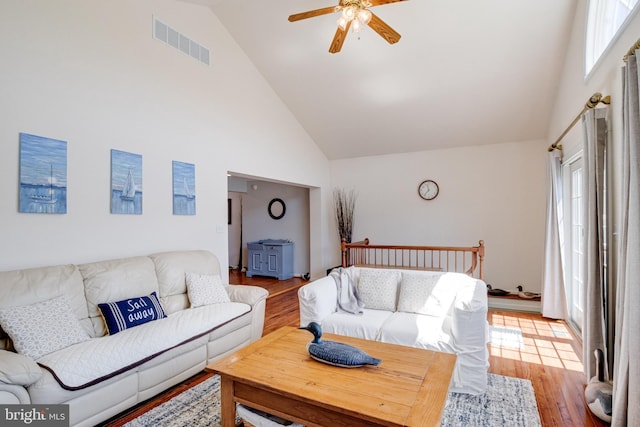 living area featuring high vaulted ceiling, ceiling fan, plenty of natural light, and wood finished floors