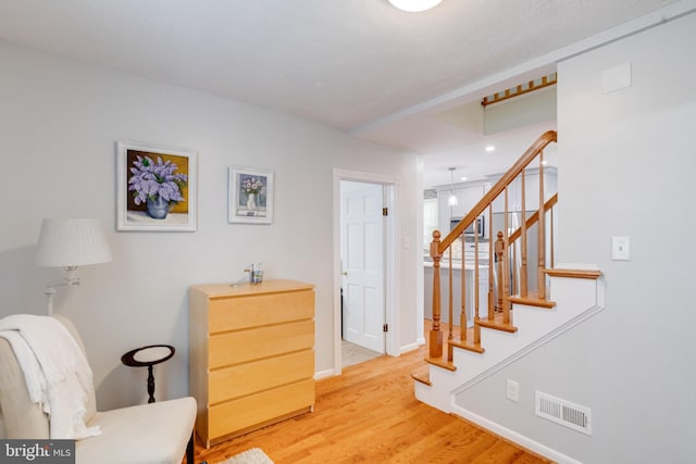 living area featuring wood finished floors, baseboards, stairway, and recessed lighting