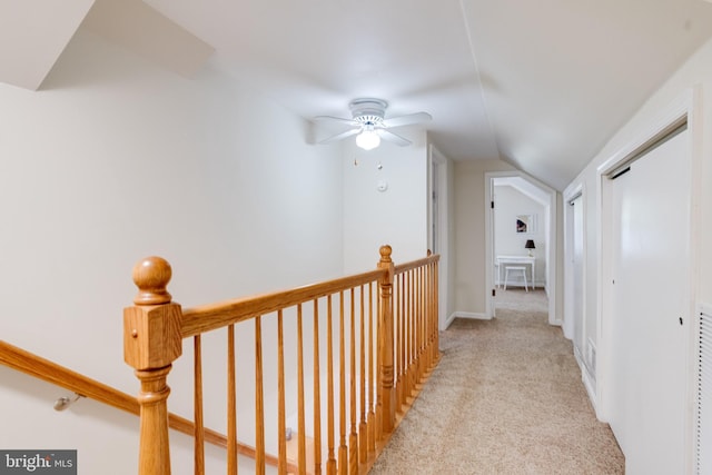 corridor with vaulted ceiling, carpet floors, and an upstairs landing