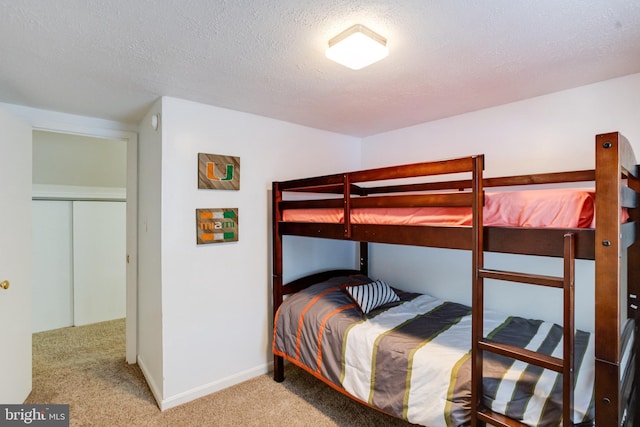 bedroom featuring carpet, a textured ceiling, and baseboards
