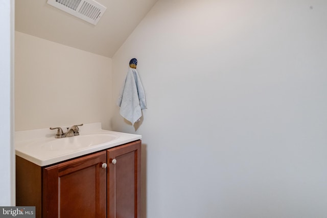 bathroom featuring vanity and lofted ceiling