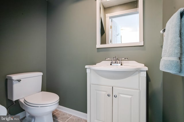 bathroom featuring baseboards, toilet, vanity, and tile patterned flooring