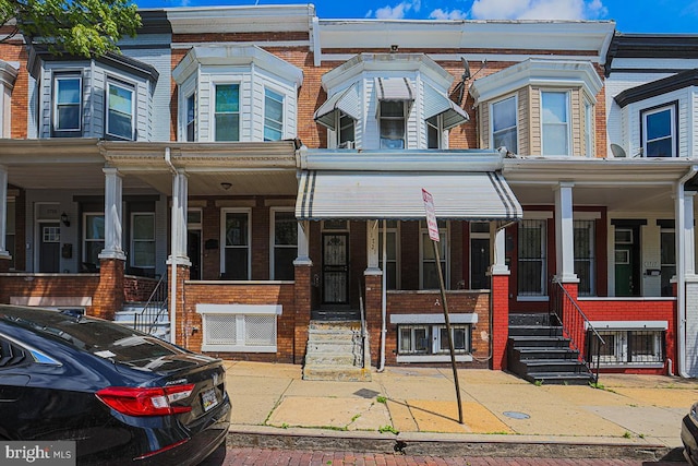 1721 Ruxton Ave, Baltimore, MD 21216 - townhome / multi-family property with a porch and brick siding