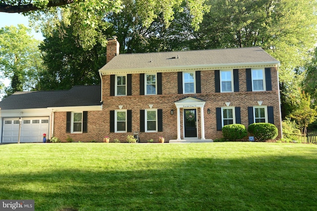 9825 Vale Rd, Vienna, VA 22181 - view of front of property featuring a chimney, an attached garage, a front lawn, and brick siding