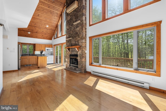 2107 Lenape Ter, Canadensis, PA 18325 - unfurnished living room with a baseboard radiator, a wall mounted AC, high vaulted ceiling, healthy amount of natural light, and light wood-style flooring
