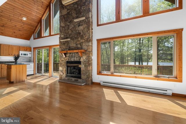 2107 Lenape Ter, Canadensis, PA 18325 - unfurnished living room featuring high vaulted ceiling, baseboard heating, light wood-type flooring, a fireplace, and baseboards