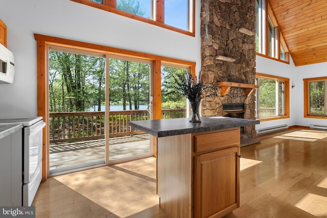 2107 Lenape Ter, Canadensis, PA 18325 - kitchen featuring baseboard heating, white electric range oven, high vaulted ceiling, light wood-style flooring, and a stone fireplace