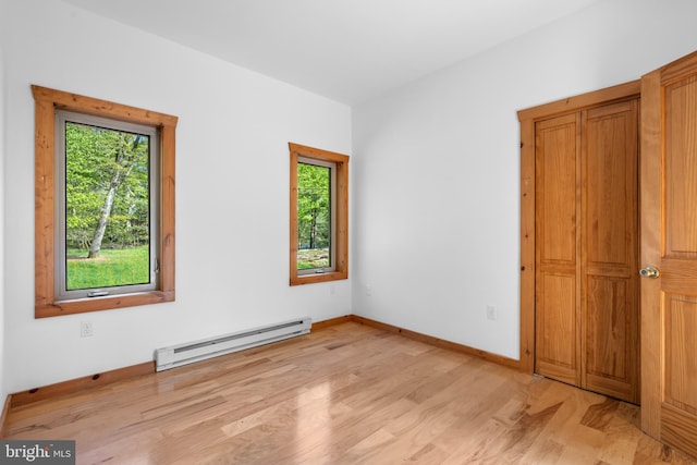 2107 Lenape Ter, Canadensis, PA 18325 - unfurnished bedroom with a baseboard radiator, multiple windows, light wood-style floors, and baseboards