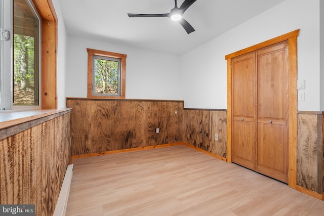 2107 Lenape Ter, Canadensis, PA 18325 - empty room with wainscoting, light wood finished floors, ceiling fan, and wooden walls