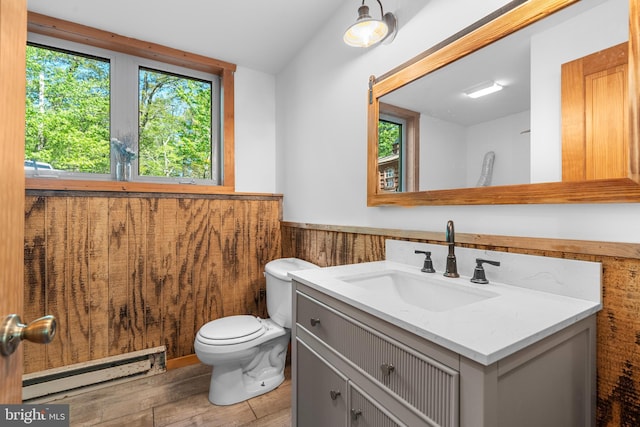 2107 Lenape Ter, Canadensis, PA 18325 - bathroom featuring a baseboard heating unit, wainscoting, vanity, toilet, and wood finished floors