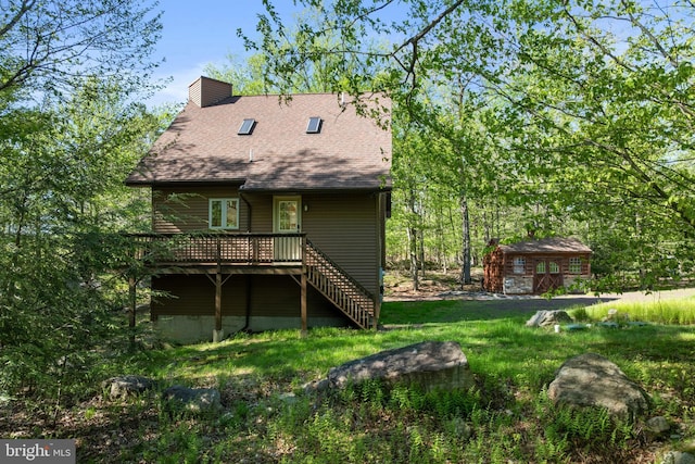 2107 Lenape Ter, Canadensis, PA 18325 - back of property featuring a wooden deck, a chimney, an outbuilding, and roof with shingles