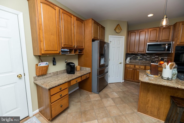 294 Arthur Ave, Port Deposit, MD 21904 - kitchen featuring appliances with stainless steel finishes, brown cabinetry, light stone counters, backsplash, and pendant lighting