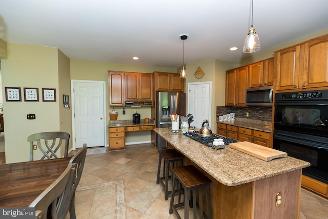 294 Arthur Ave, Port Deposit, MD 21904 - kitchen with stainless steel appliances, light stone counters, a kitchen bar, a kitchen island, and decorative light fixtures