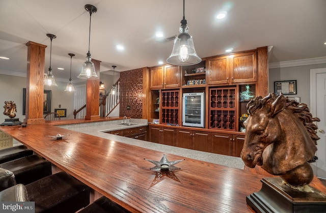318 Ironstone Ln, Elverson, PA 19520 - bar featuring wine cooler, stairway, ornamental molding, hanging light fixtures, and a sink