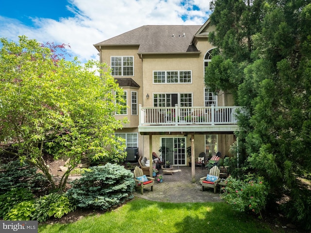 318 Ironstone Ln, Elverson, PA 19520 - back of property with stucco siding, a patio, a deck, a shingled roof, and a yard