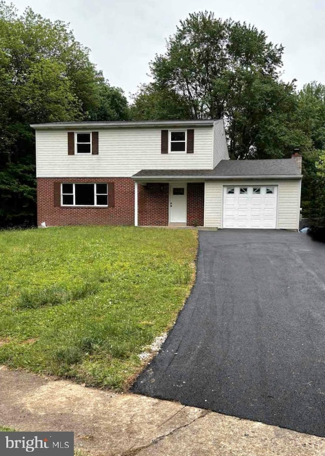 585 Andrew Dr, Southampton, PA 18966 - traditional home featuring an attached garage, asphalt driveway, a front yard, and brick siding